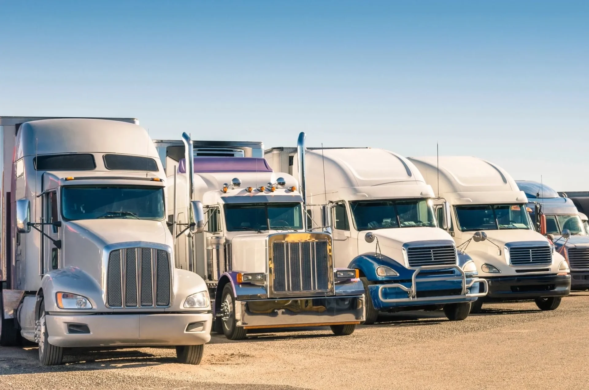 A row of trucks parked in a parking lot.